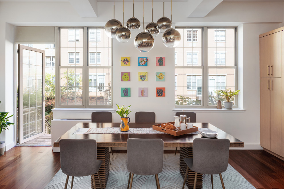 Cette image montre une salle à manger design avec un mur blanc, parquet foncé et un sol marron.