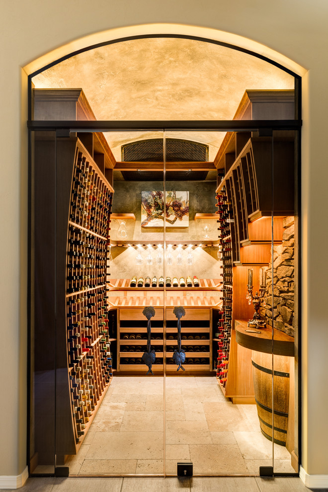 This is an example of a mid-sized traditional wine cellar in Phoenix with travertine floors and display racks.