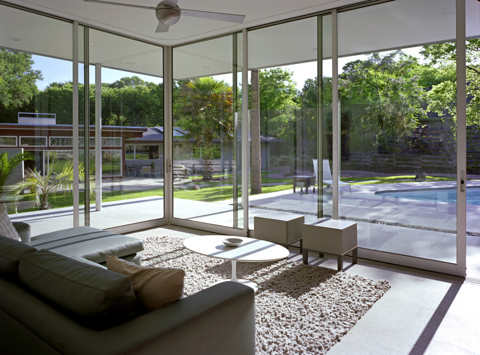 Photo of a large modern sunroom in Austin with concrete floors, no fireplace, a standard ceiling and grey floor.