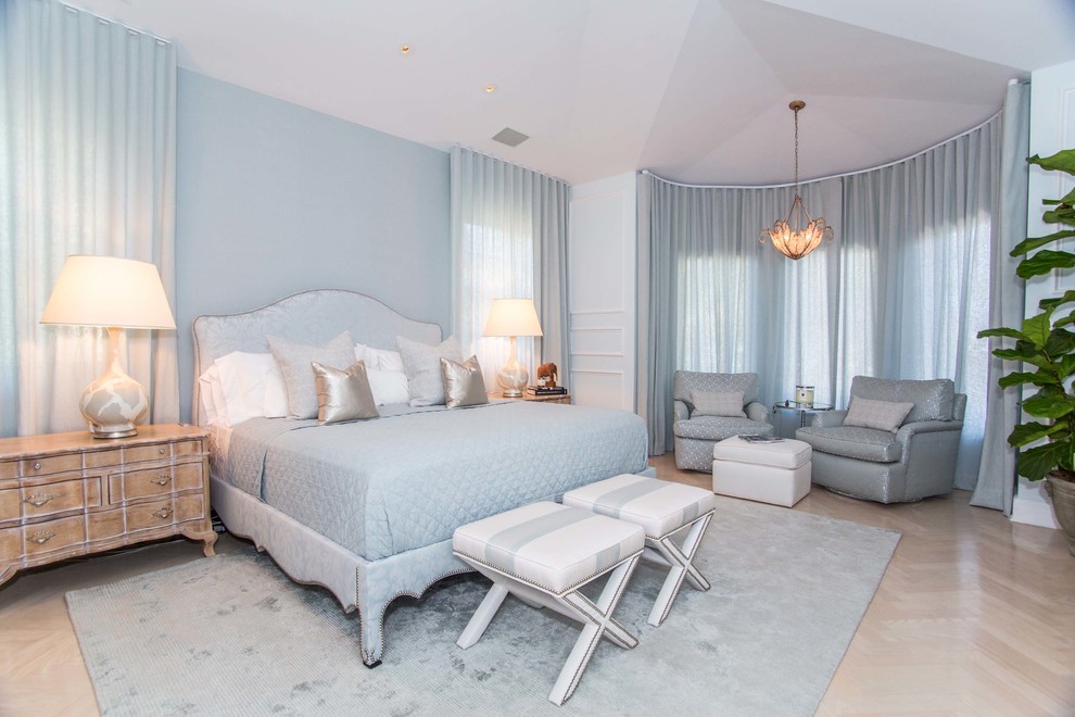 This is an example of a transitional bedroom in Miami with blue walls.