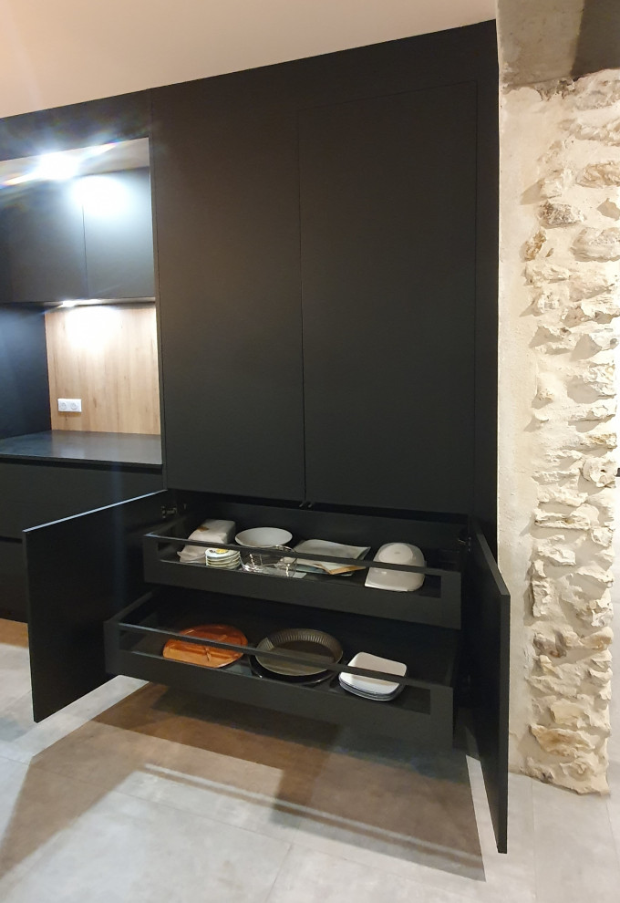Inspiration for a large contemporary galley open plan kitchen in Other with a submerged sink, flat-panel cabinets, black cabinets, granite worktops, black splashback, glass sheet splashback, integrated appliances, cement flooring, an island, grey floors and black worktops.