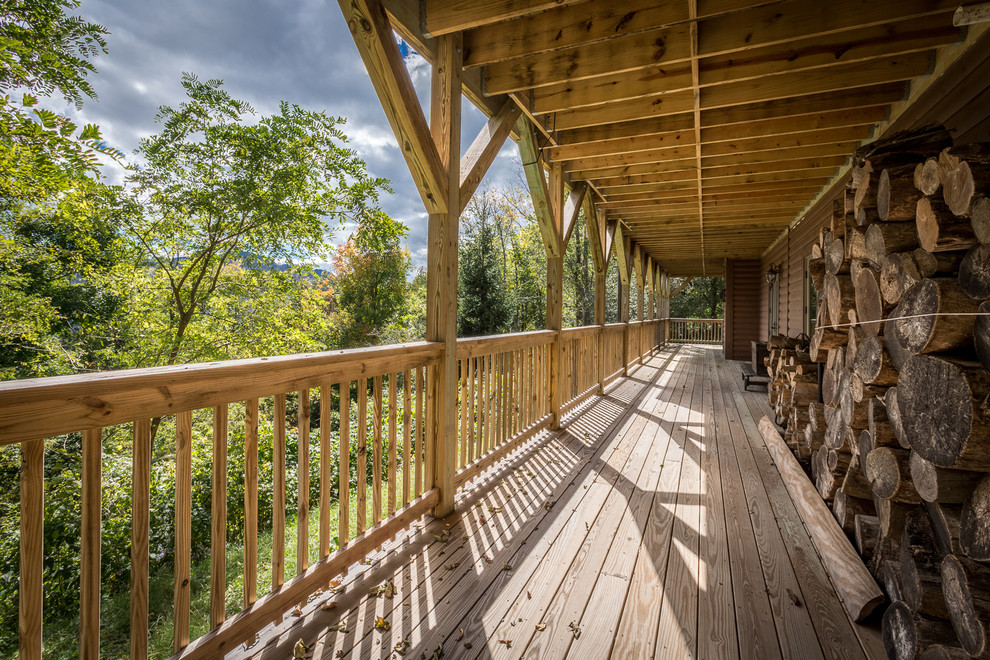 Inspiration for a huge rustic backyard deck remodel in Charlotte with a roof extension