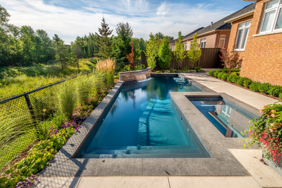 Small transitional backyard stamped concrete and rectangular pool landscaping photo in Toronto
