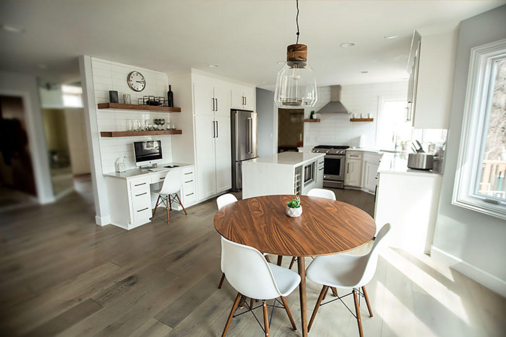 Inspiration for a mid-sized transitional u-shaped medium tone wood floor and brown floor kitchen remodel in Omaha with an undermount sink, shaker cabinets, white cabinets, quartzite countertops, white backsplash, ceramic backsplash, stainless steel appliances, an island and white countertops
