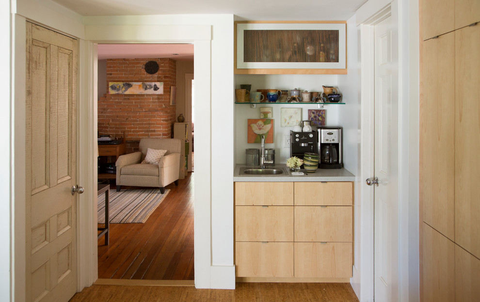 Photo of a mid-sized contemporary galley kitchen pantry in Boston with glass-front cabinets, light wood cabinets, laminate benchtops, white splashback, stainless steel appliances, bamboo floors, no island and an undermount sink.