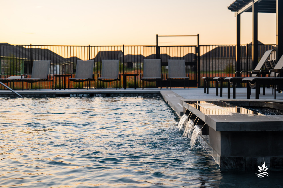Idee per un'ampia piscina naturale stile rurale personalizzata in cortile con paesaggistica bordo piscina e lastre di cemento