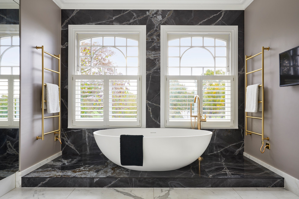 Aménagement d'une salle de bain principale et grise et blanche contemporaine avec une baignoire indépendante, un carrelage noir, des carreaux de porcelaine, un mur beige, un sol en marbre et un sol jaune.
