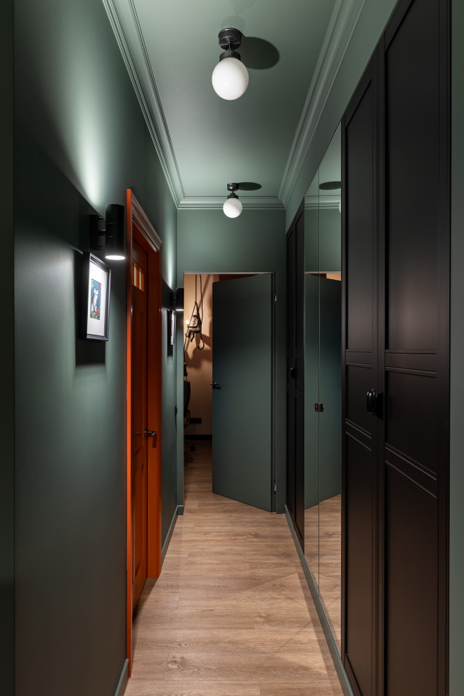 Cette image montre une petite entrée design avec un couloir, un sol en bois brun, une porte simple, une porte orange et un sol marron.