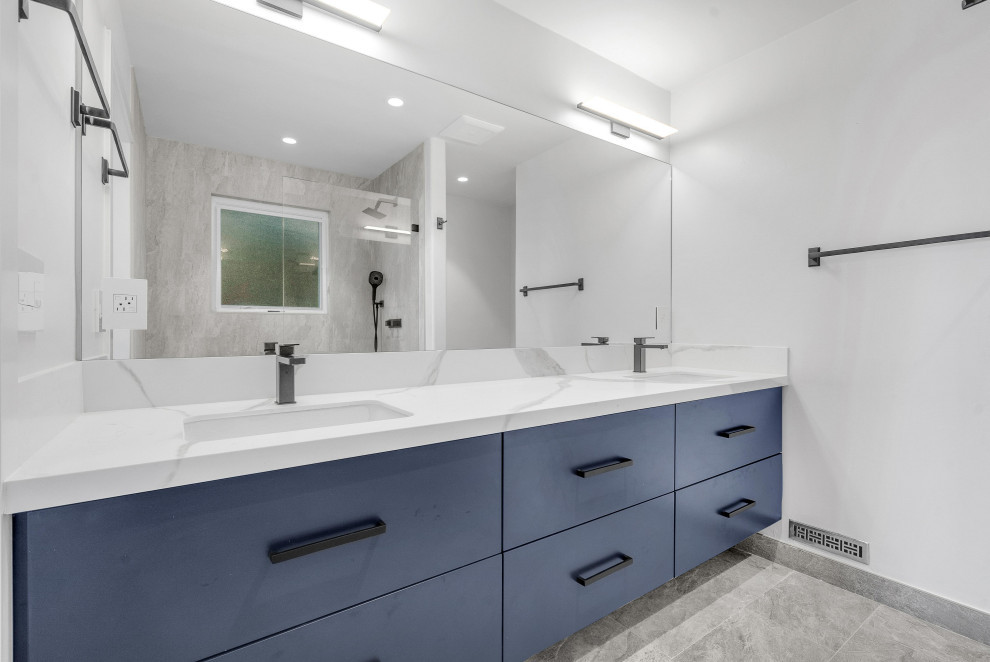 Aménagement d'une salle de bain moderne avec un placard à porte plane, des portes de placard bleues et meuble double vasque.