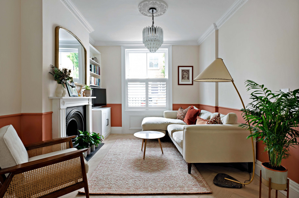 This is an example of a classic living room in London with light hardwood flooring, a stone fireplace surround and a dado rail.