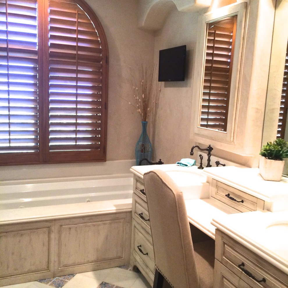 Mid-sized transitional master blue tile and porcelain tile ceramic tile and blue floor wet room photo with raised-panel cabinets, distressed cabinets, an undermount tub, beige walls, an undermount sink, solid surface countertops and a hinged shower door