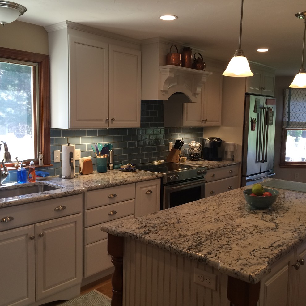 Example of a transitional u-shaped medium tone wood floor eat-in kitchen design in Boston with an undermount sink, raised-panel cabinets, white cabinets, granite countertops, blue backsplash, glass tile backsplash, stainless steel appliances and an island