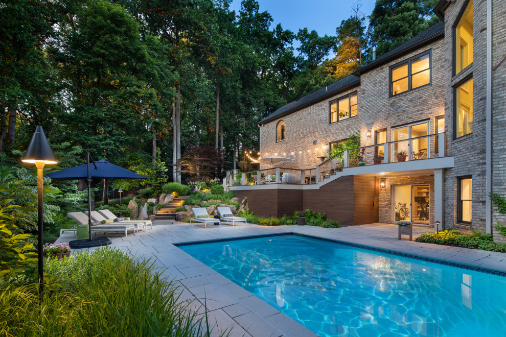 Transitional stone and rectangular pool landscaping photo in DC Metro