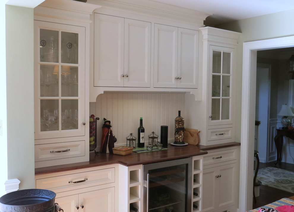Eat-in kitchen - large transitional l-shaped medium tone wood floor eat-in kitchen idea in Philadelphia with a farmhouse sink, recessed-panel cabinets, white cabinets, white backsplash, stainless steel appliances and an island