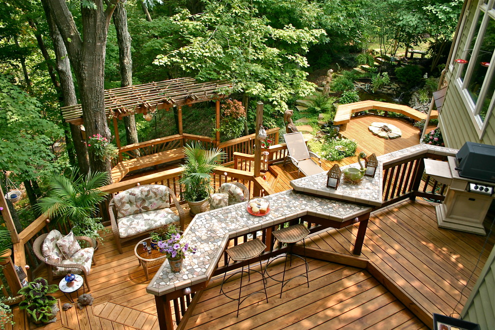 Design ideas for an expansive traditional backyard deck in Other with a pergola and a fire feature.