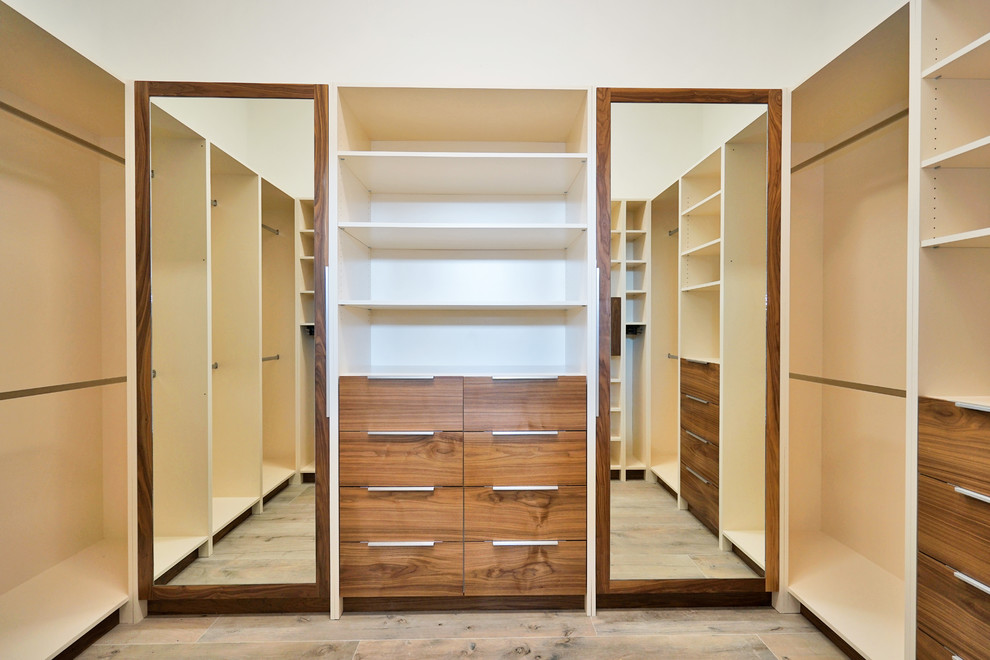 Large modern men's walk-in wardrobe in Miami with flat-panel cabinets, dark wood cabinets, laminate floors and brown floor.