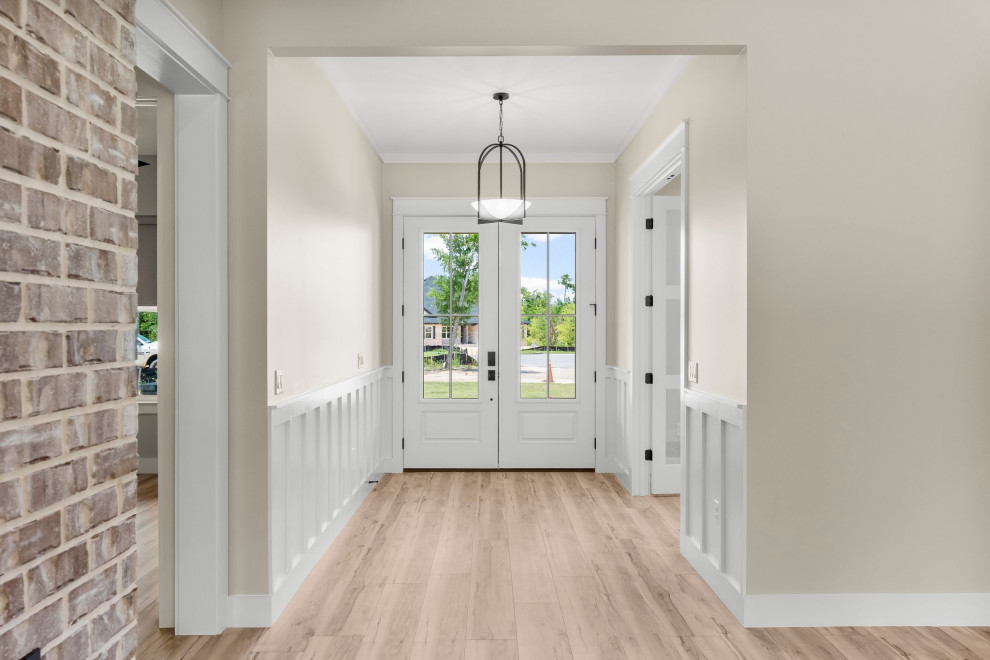 Inspiration for a mid-sized craftsman vinyl floor, beige floor and wainscoting foyer remodel with beige walls and a white front door