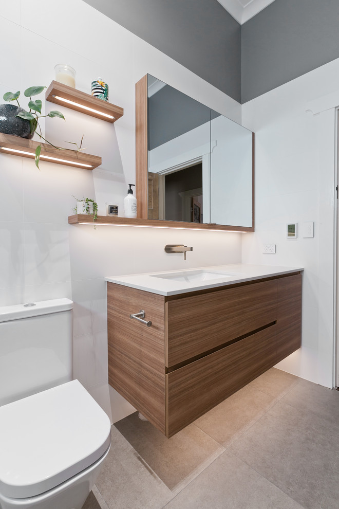Photo of a mid-sized modern kids bathroom in Perth with medium wood cabinets, an open shower, a one-piece toilet, white tile, cement tile, grey walls, porcelain floors, an undermount sink, engineered quartz benchtops, grey floor and white benchtops.