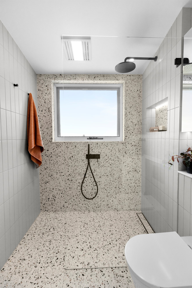 На фото: главная ванная комната среднего размера в современном стиле с плоскими фасадами, белыми фасадами, душевой комнатой, унитазом-моноблоком, разноцветной плиткой, плиткой кабанчик, разноцветными стенами, полом из терраццо, настольной раковиной, столешницей из искусственного камня, разноцветным полом, открытым душем, белой столешницей, нишей, тумбой под одну раковину, встроенной тумбой и сводчатым потолком с