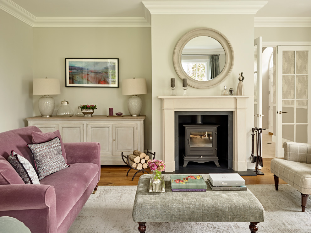 Inspiration for a traditional formal enclosed living room in Sussex with grey walls, medium hardwood floors, a wood stove, no tv and brown floor.