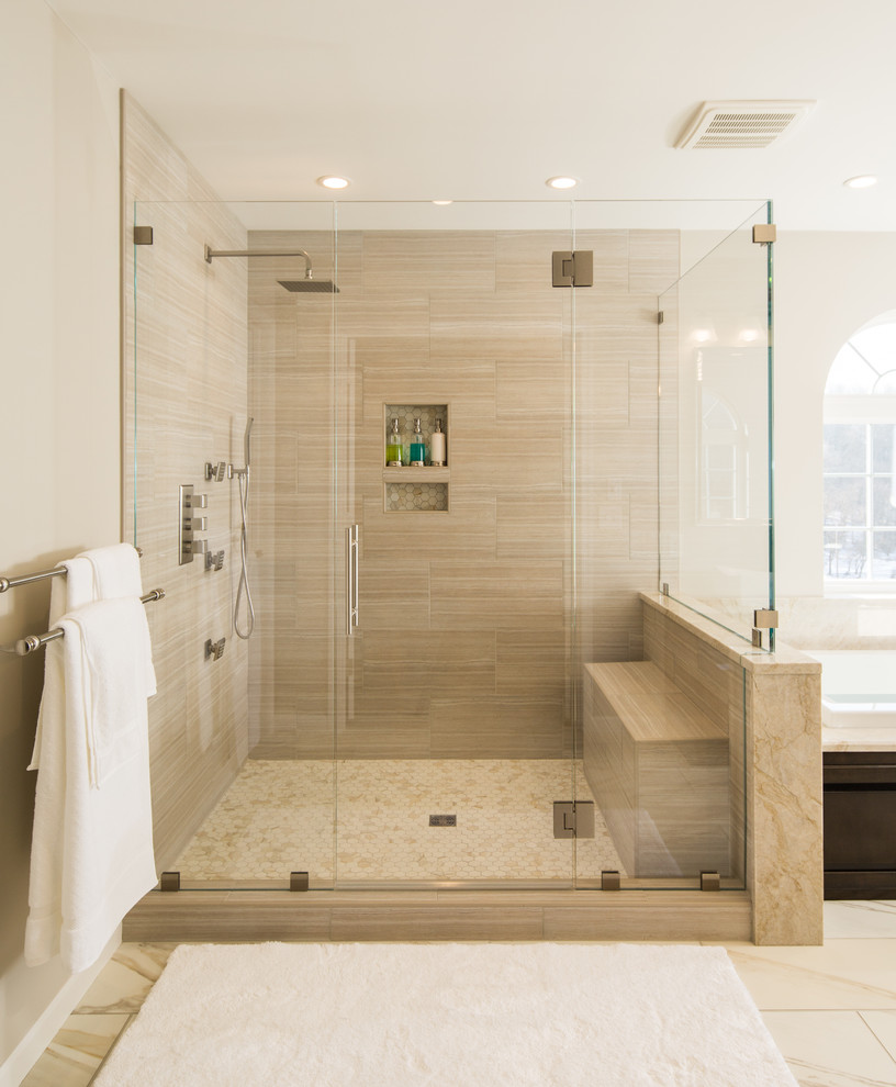 Inspiration for a large transitional master bathroom in Philadelphia with recessed-panel cabinets, dark wood cabinets, a drop-in tub, a corner shower, beige tile, marble, beige walls, ceramic floors, marble benchtops, beige floor, a hinged shower door and a vessel sink.