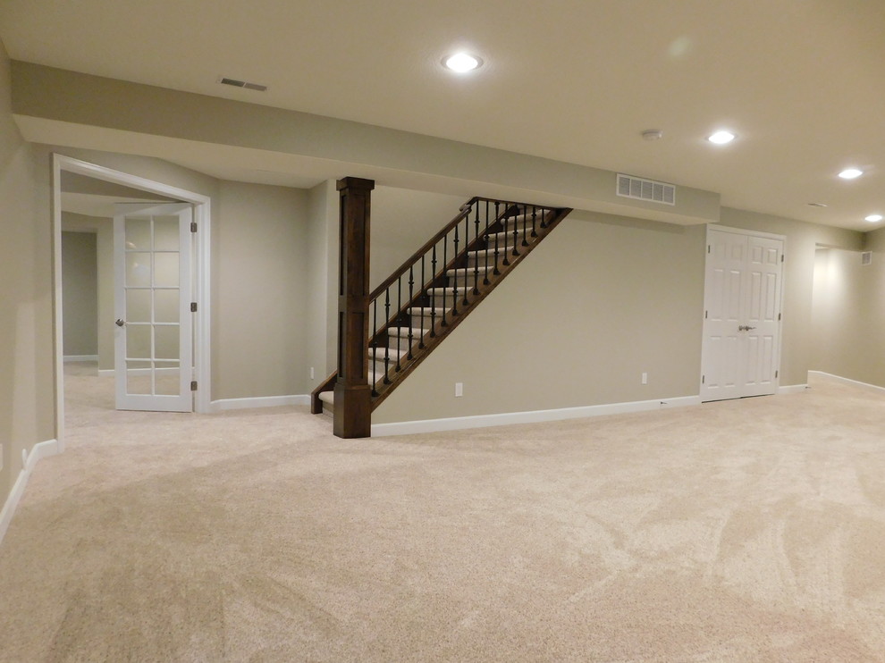 Design ideas for a mid-sized contemporary look-out basement in Denver with beige walls and carpet.