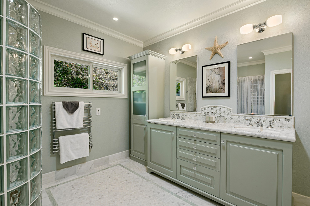 Photo of a mid-sized modern master bathroom in San Francisco with an undermount sink, raised-panel cabinets, green cabinets, marble benchtops, a curbless shower, a one-piece toilet, white tile, stone tile, green walls and mosaic tile floors.