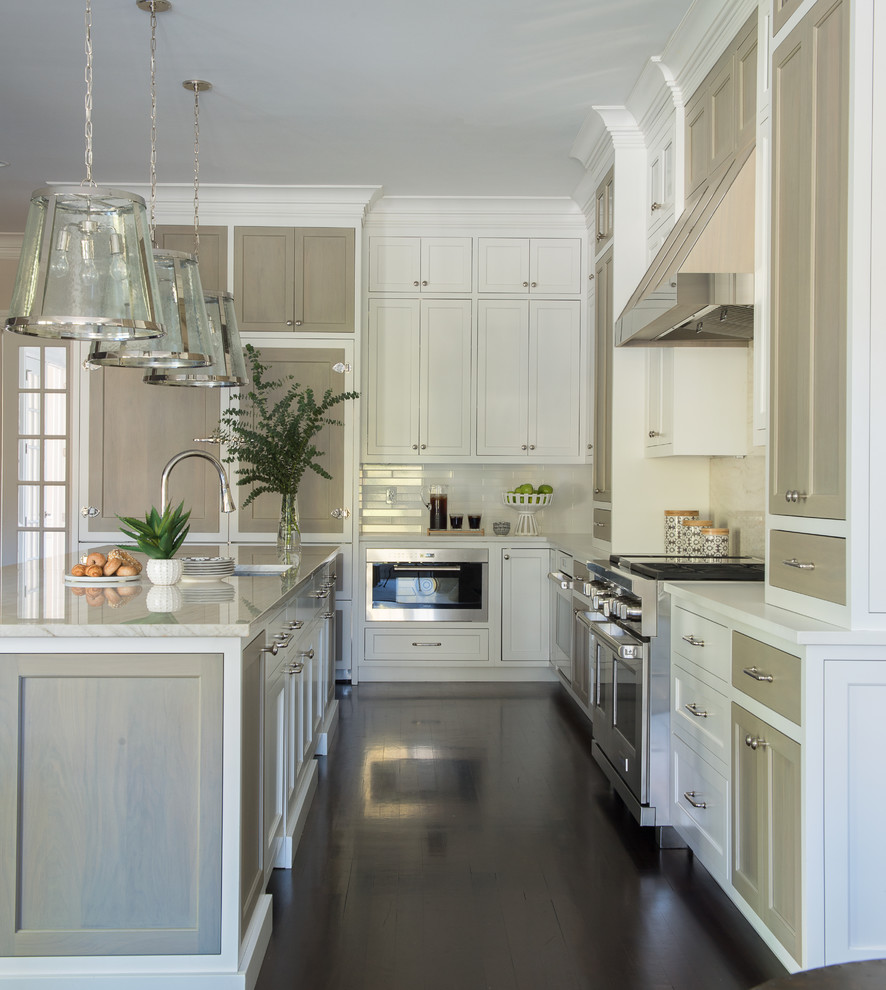 Transitional l-shaped eat-in kitchen in New York with a farmhouse sink, recessed-panel cabinets, light wood cabinets, marble benchtops, beige splashback, marble splashback, stainless steel appliances, dark hardwood floors, with island and white benchtop.