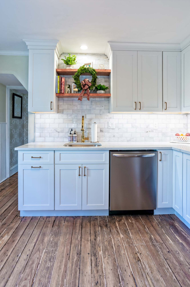 This is an example of a small country l-shaped separate kitchen in Philadelphia with an undermount sink, shaker cabinets, yellow cabinets, quartz benchtops, white splashback, stone tile splashback, medium hardwood floors, no island, brown floor and white benchtop.