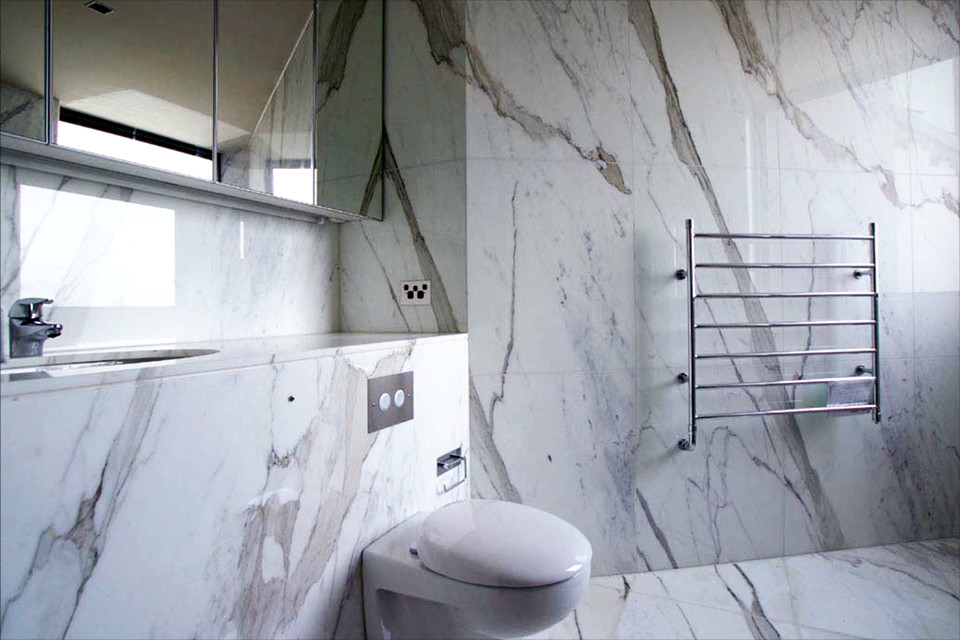 Photo of a contemporary bathroom in Sydney with a two-piece toilet, black and white tile, stone slab, marble floors, a drop-in sink and marble benchtops.