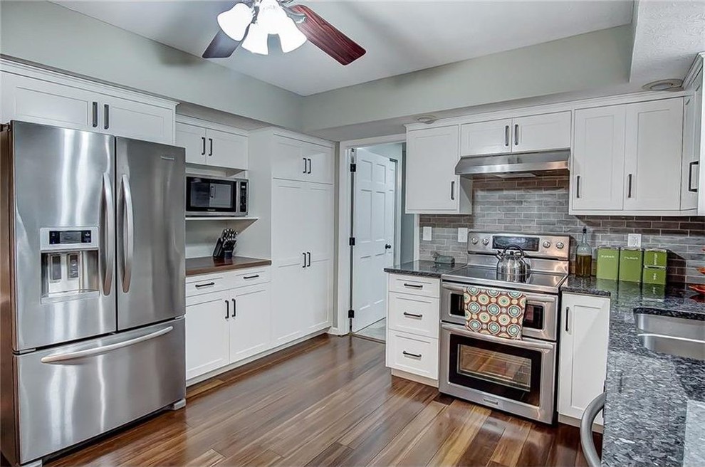 Kitchen - transitional medium tone wood floor kitchen idea with shaker cabinets, white cabinets and granite countertops