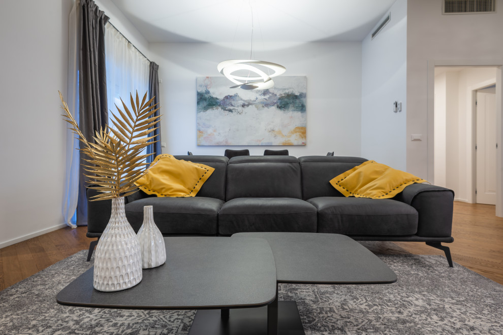 Стильный дизайн: открытая гостиная комната среднего размера в стиле модернизм с белыми стенами, темным паркетным полом, телевизором на стене и коричневым полом - последний тренд