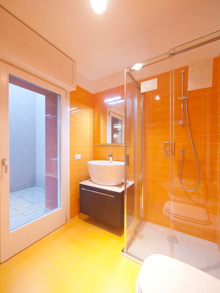 Design ideas for a small modern kids bathroom in Milan with a console sink, flat-panel cabinets, brown cabinets, laminate benchtops, a corner shower, a two-piece toilet, yellow tile, porcelain tile, yellow walls and porcelain floors.