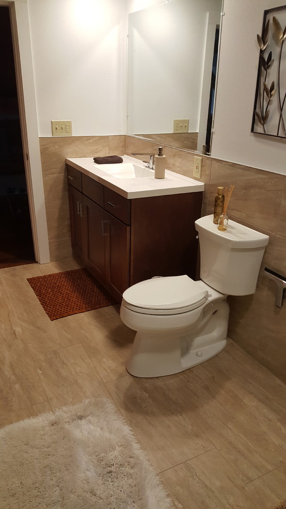 Inspiration for a large transitional 3/4 bathroom with shaker cabinets, dark wood cabinets, an alcove shower, brown tile, porcelain tile, white walls, porcelain floors, engineered quartz benchtops, brown floor, a hinged shower door and an integrated sink.