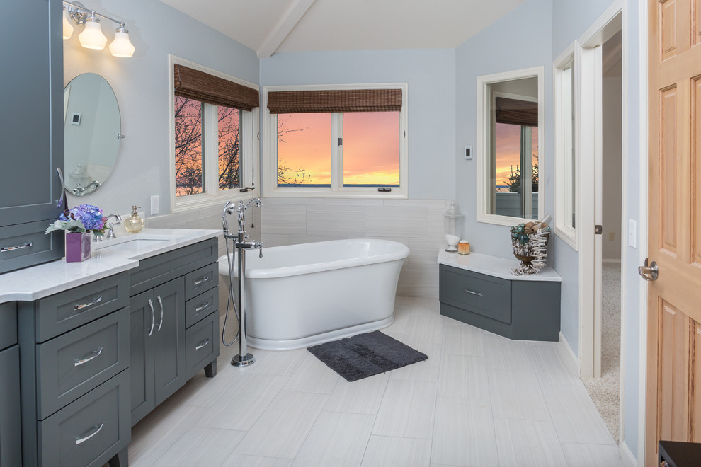 Freestanding bathtub - mid-sized transitional master white tile and porcelain tile porcelain tile freestanding bathtub idea with an undermount sink, shaker cabinets, gray cabinets, quartz countertops, a one-piece toilet and gray walls