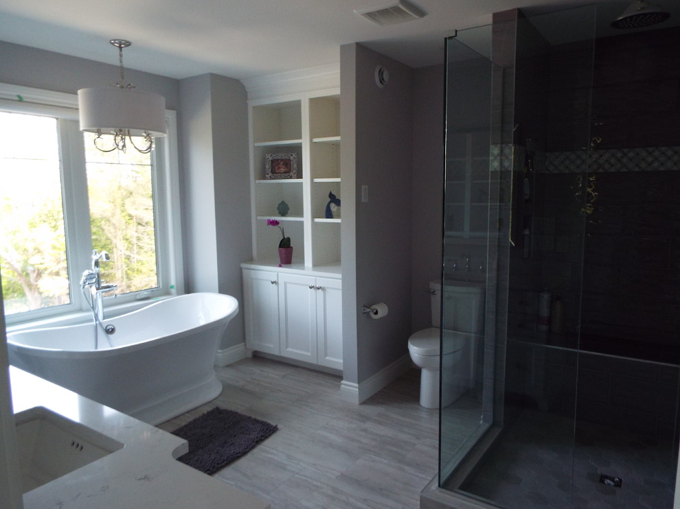 This is an example of a mid-sized contemporary master wet room bathroom in Other with white cabinets, engineered quartz benchtops, grey floor, a hinged shower door and white benchtops.