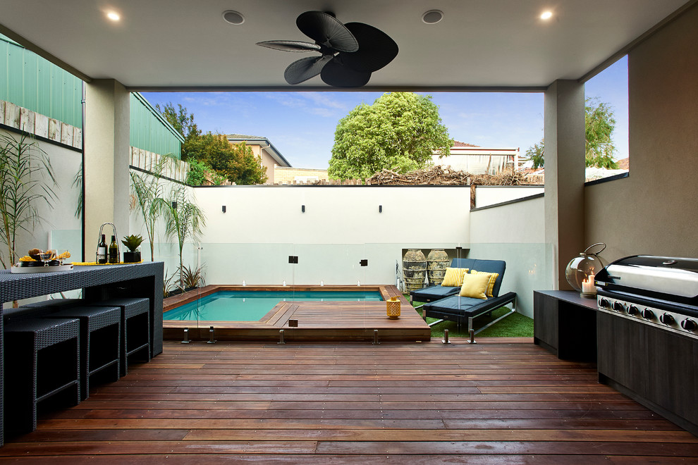 Photo of a contemporary deck in Melbourne with an outdoor kitchen and a roof extension.