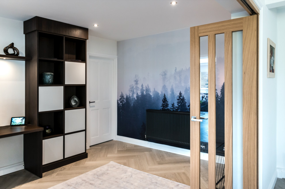 Diseño de despacho actual de tamaño medio con paredes blancas, suelo vinílico, estufa de leña, escritorio empotrado, suelo beige y panelado