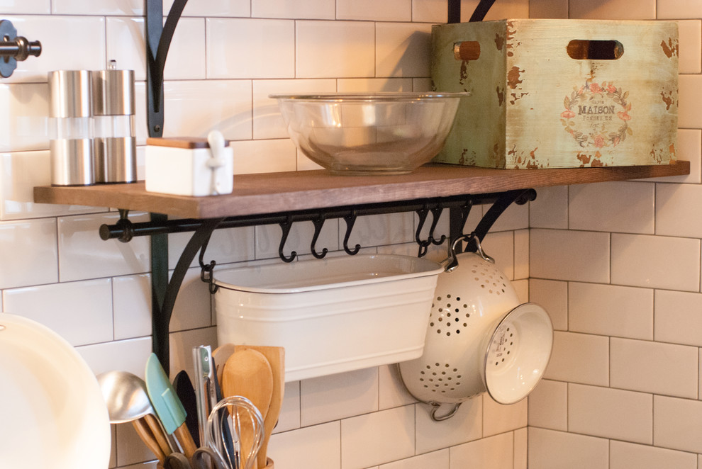 Example of a small transitional u-shaped ceramic tile home design design with an undermount sink, raised-panel cabinets, white cabinets, solid surface countertops, white backsplash, subway tile backsplash, stainless steel appliances and no island