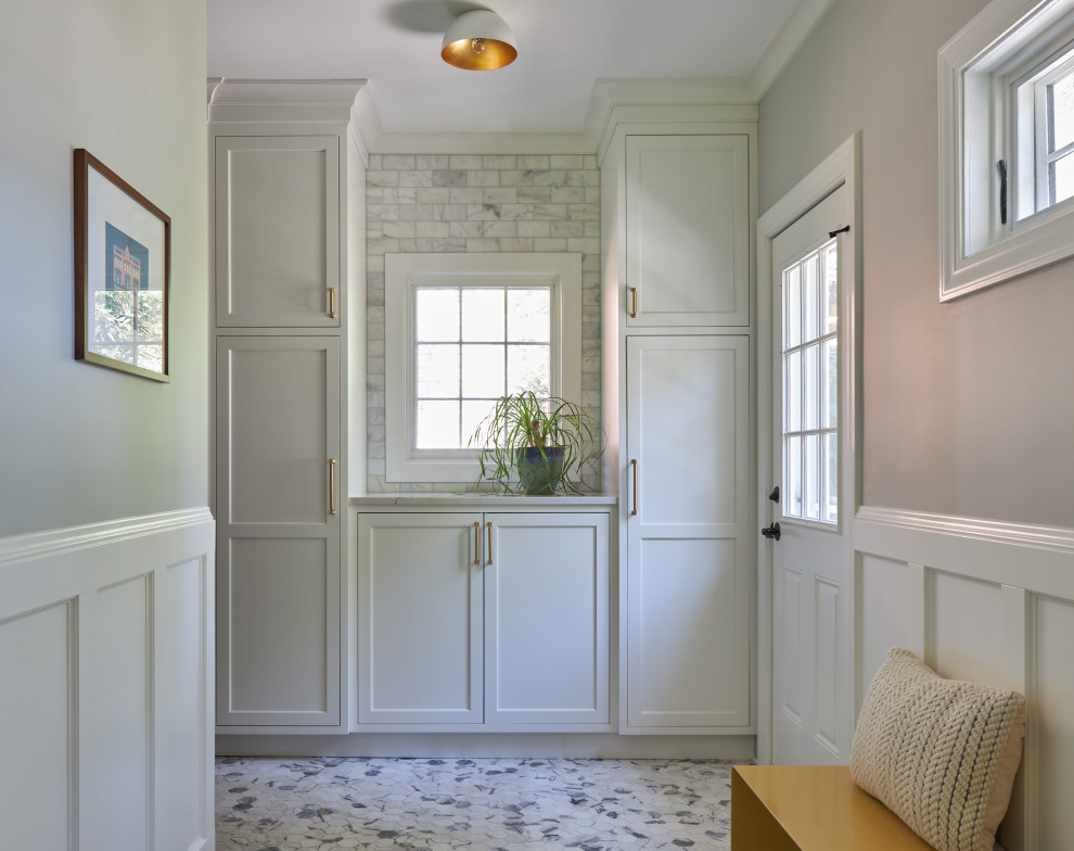 This is an example of a small transitional mudroom in Chicago with beige walls, marble floors, a single front door, a white front door, grey floor and decorative wall panelling.