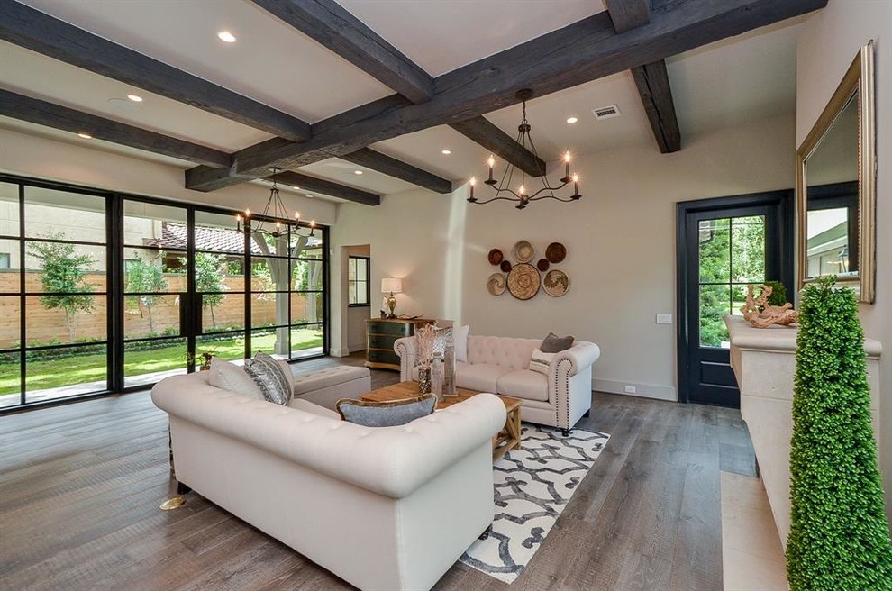 This is an example of an expansive transitional open concept family room in Houston with white walls, medium hardwood floors, a standard fireplace, a stone fireplace surround, a wall-mounted tv and grey floor.