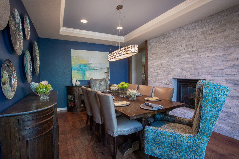 Photo of a contemporary separate dining room in Denver with blue walls, medium hardwood floors, a two-sided fireplace and a stone fireplace surround.