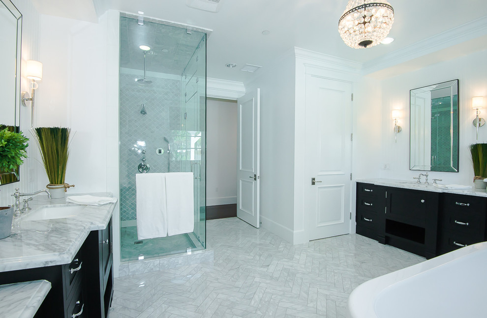 Mid-sized transitional master bathroom in Dallas with flat-panel cabinets, black cabinets, a claw-foot tub, a corner shower, a two-piece toilet, gray tile, stone tile, white walls, marble floors, an undermount sink, marble benchtops, white floor and a hinged shower door.