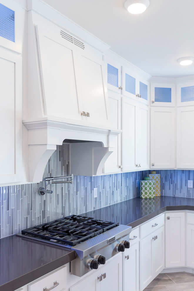 Inspiration for an expansive transitional l-shaped open plan kitchen in Salt Lake City with an undermount sink, shaker cabinets, white cabinets, solid surface benchtops, blue splashback, mosaic tile splashback, stainless steel appliances, porcelain floors and with island.