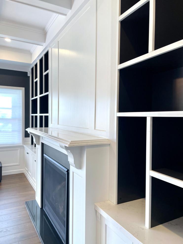 Идея дизайна: большая открытая гостиная комната в классическом стиле с с книжными шкафами и полками, черными стенами, паркетным полом среднего тона, стандартным камином, фасадом камина из дерева, коричневым полом и кессонным потолком