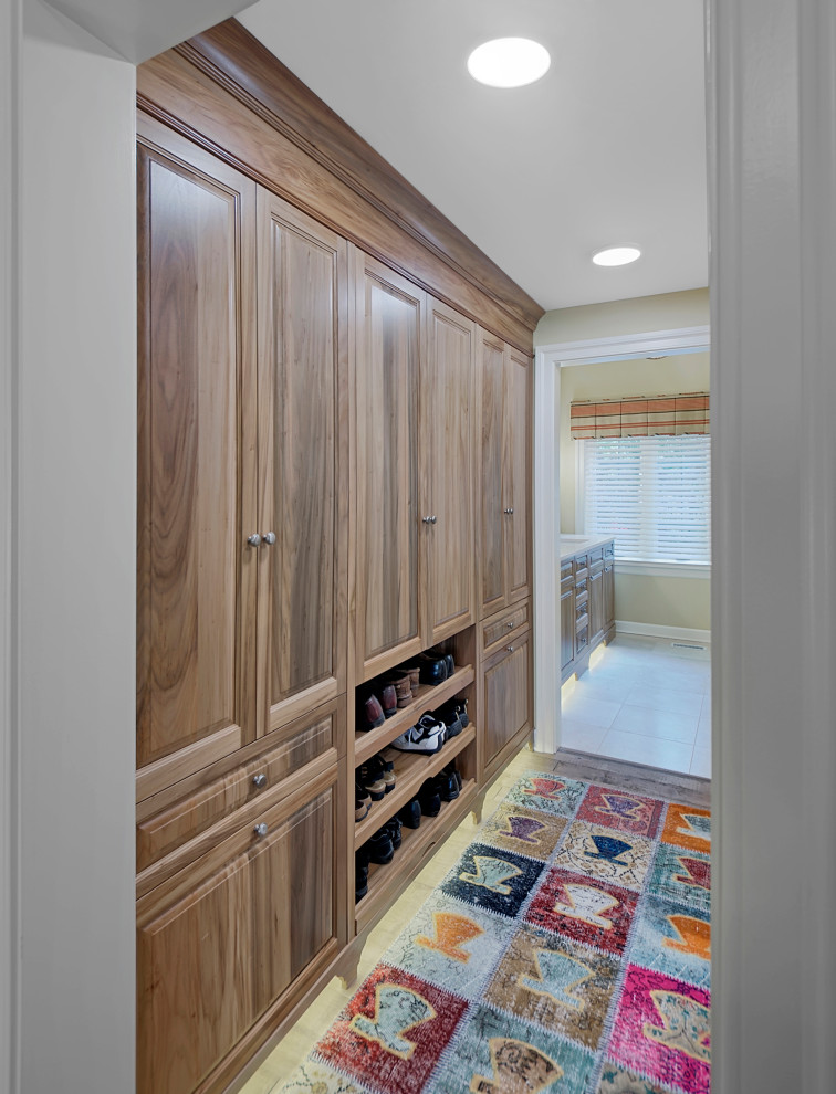 Inspiration for a mid-sized country gender-neutral storage and wardrobe in Chicago with recessed-panel cabinets, medium wood cabinets, dark hardwood floors and brown floor.