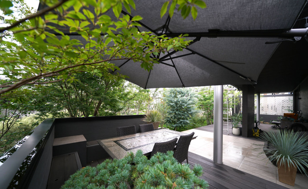 Idée de décoration pour une très grande terrasse avant minimaliste avec une cuisine d'été, un auvent et du carrelage.