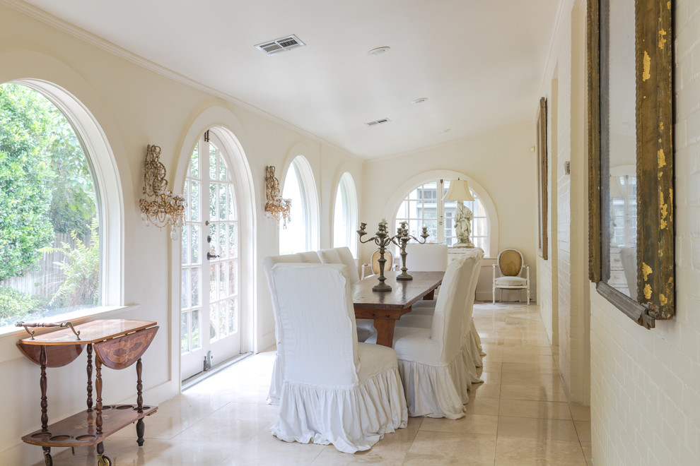 Inspiration for a mid-sized traditional separate dining room in New Orleans with white walls, limestone floors, no fireplace and beige floor.