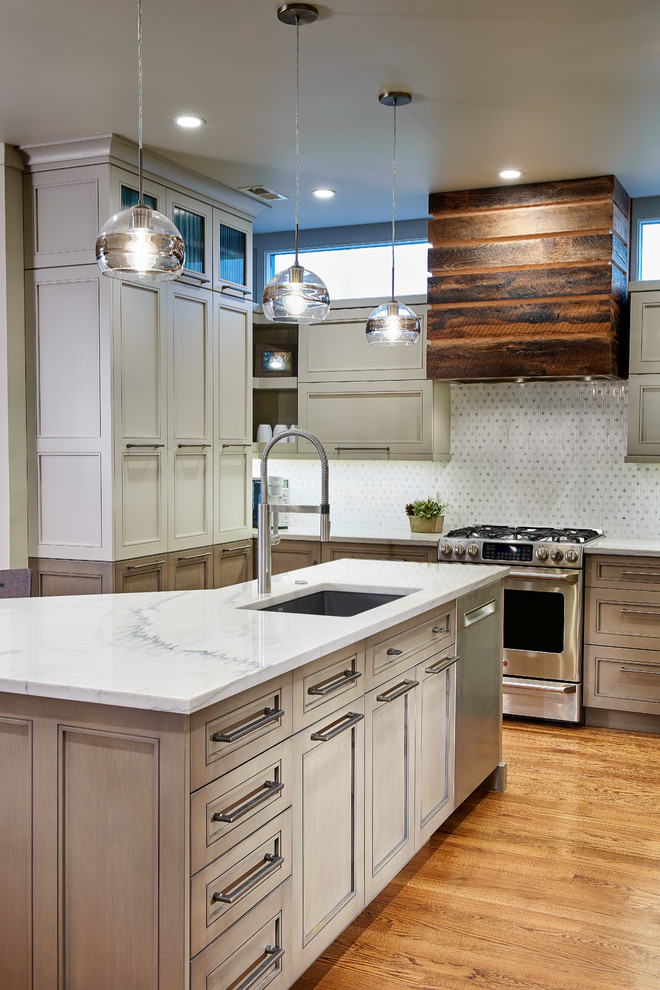 Mid-sized minimalist u-shaped medium tone wood floor and brown floor open concept kitchen photo with an undermount sink, recessed-panel cabinets, beige cabinets, granite countertops, white backsplash, ceramic backsplash, stainless steel appliances, an island and white countertops