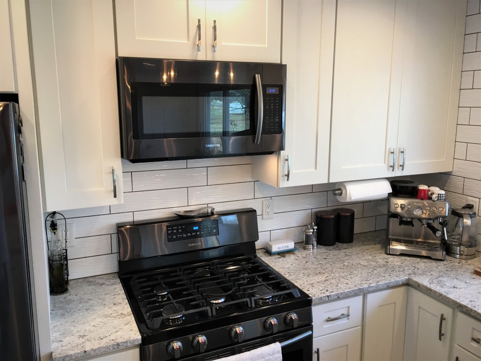 Inspiration for a mid-sized contemporary u-shaped porcelain tile and gray floor open concept kitchen remodel in Baltimore with an undermount sink, shaker cabinets, white cabinets, granite countertops, white backsplash, ceramic backsplash, stainless steel appliances and a peninsula